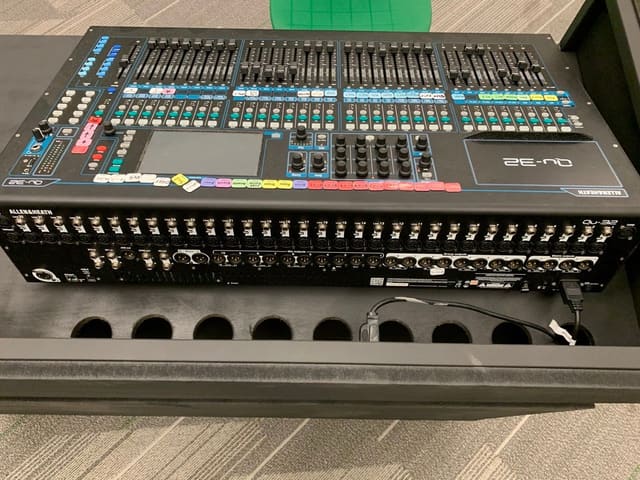 Close view of the mixing console set into the cart, with a row of cable ports cut into the panel below it.